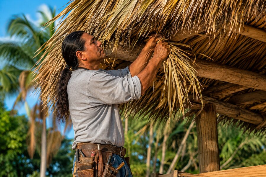 Chief Bobbie at work thatching a roof